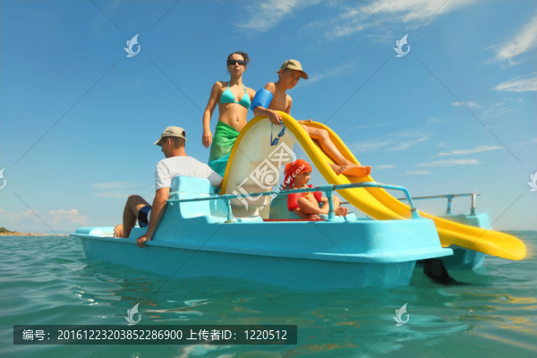 幸福的家庭與男孩和女孩在踏板船與黃色幻燈片我