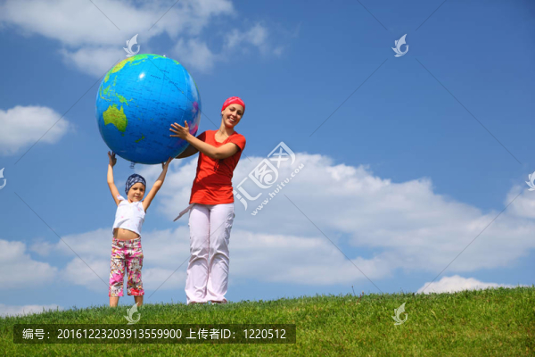 女孩抬起充氣地球上媽媽幫女兒