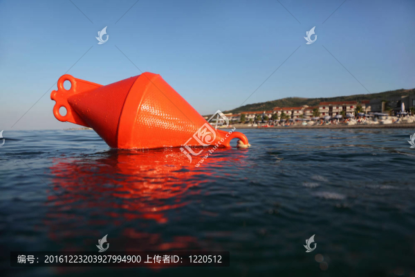 橙色浮標浮在海面上。遠處可以看到海灘