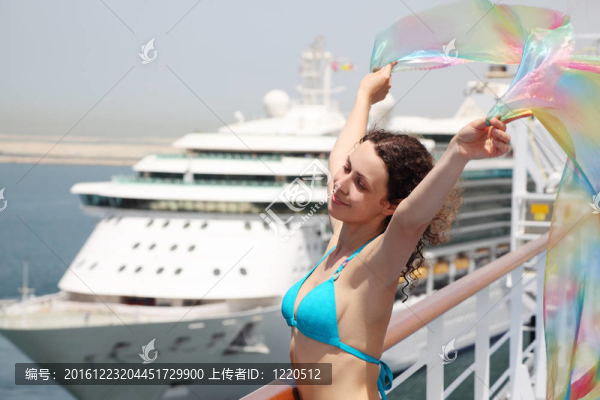 年輕美麗的女人站在郵輪的甲板在比基尼和H