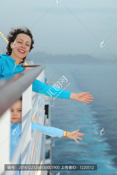 快樂的美女與女兒站在游船的甲板上
