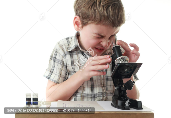 好奇的小男孩在格子襯衫，盯著黑色的顯微鏡