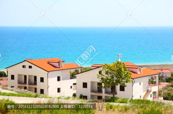 新的兩層白色房屋，棕色屋頂和陽臺在海岸