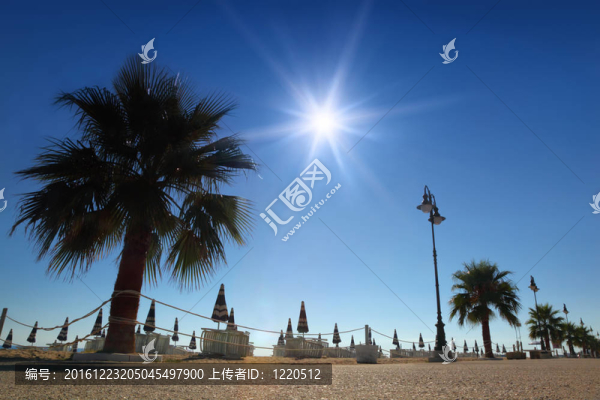 具體路徑與棕櫚海灘上的折疊傘和日光浴床；燃燒的太陽(yáng)和晴朗的天空
