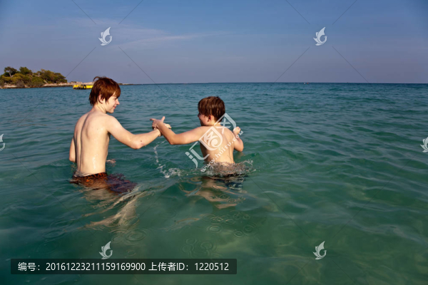 兄弟們在美麗的海灘上享受清澈的溫水