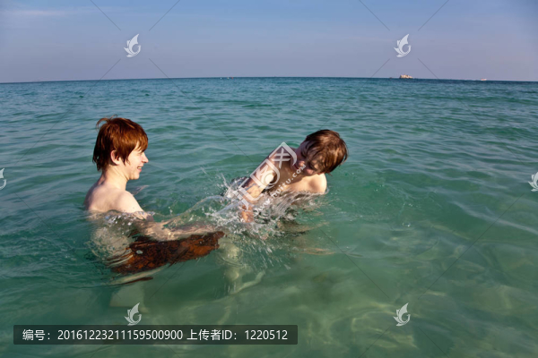 兄弟們在美麗的海灘上享受清澈的溫水