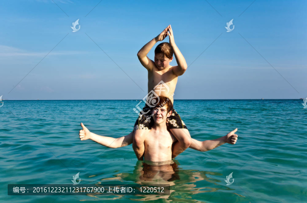 兄弟們正享受著清澈溫暖的水在美麗的海灘和玩子