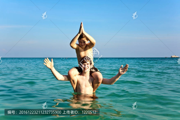 兄弟們正享受著清澈溫暖的水在美麗的海灘和玩子
