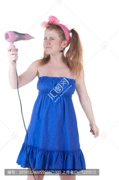 紅發(fā)女孩用吹風(fēng)機(jī)。