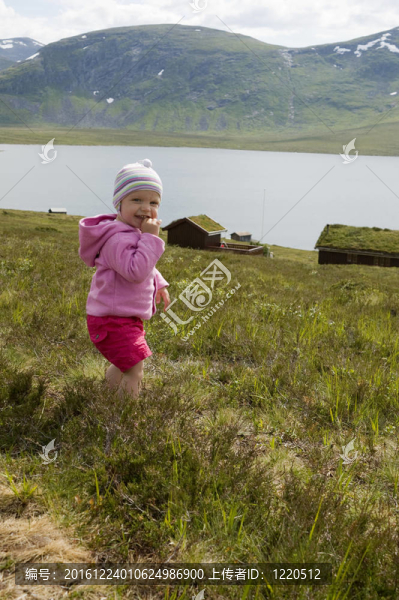 可愛的幼兒（20個月大）在高山景觀與高山湖泊和木屋的背景。
