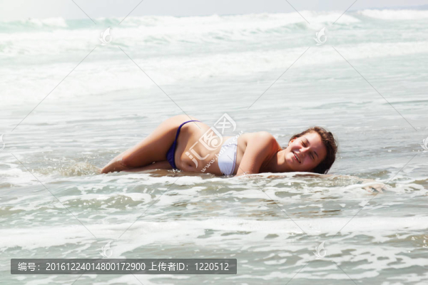 漂亮女孩的海岸上曬日光浴