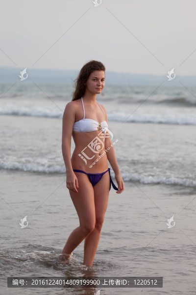 美麗的女孩在海灘上穿著游泳衣