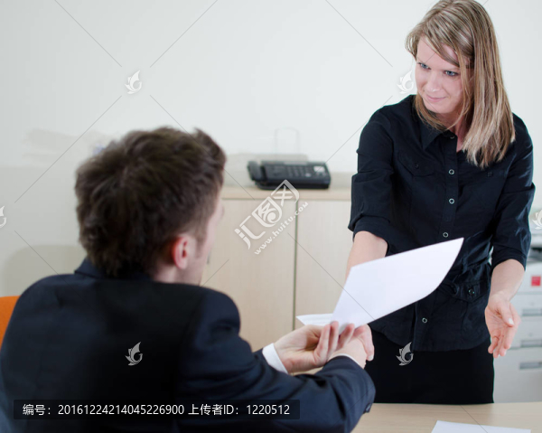年輕的商人正在給他的秘書一些文件