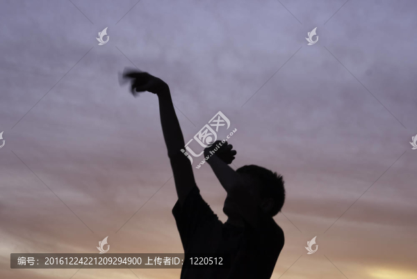 男孩投籃后的籃球剪影