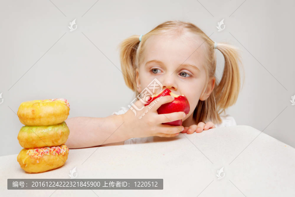 這張照片描繪了一個年輕的女孩決定健康食品和不健康食品與Y。