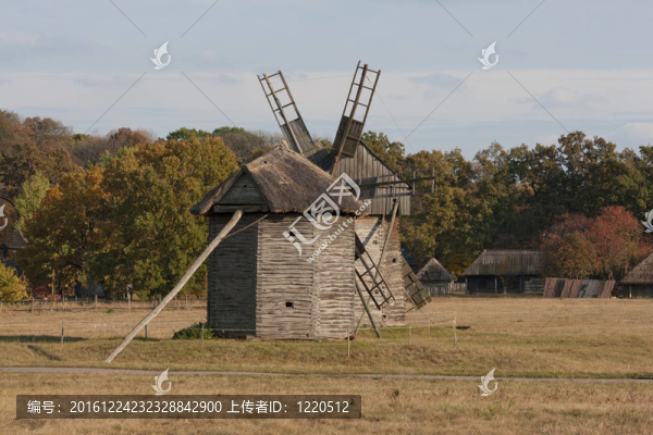 秋天的鄉(xiāng)村景觀。前景中的兩個(gè)木制風(fēng)車。背景中的樹木和小屋。
