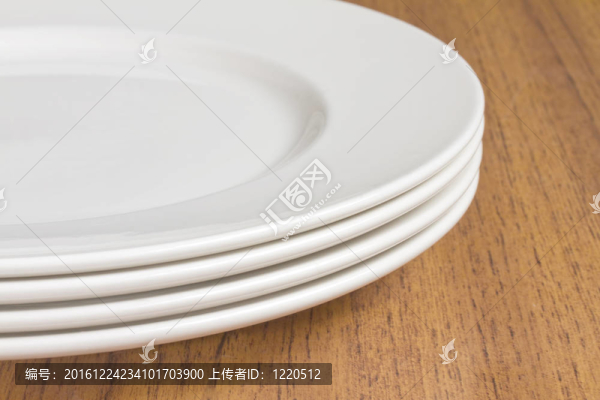 木制桌子上的四個白色盤子