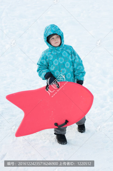 冬天用紅色的雪橇的男孩