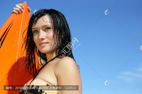 年輕女子拿著沖浪板