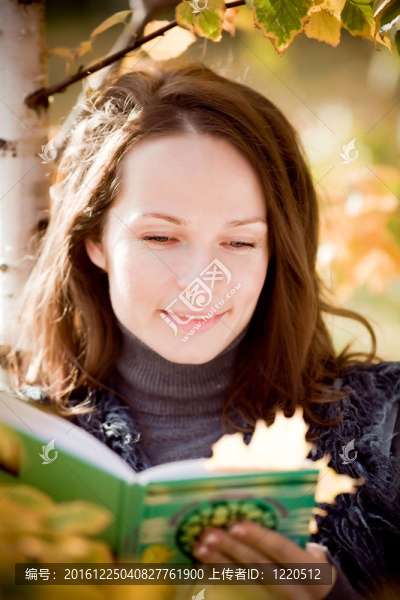 微笑的女人在秋天讀書