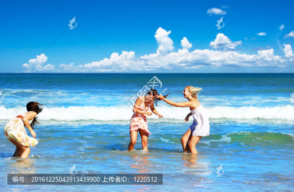 三個(gè)年輕女人在夏日的海灘上玩得很開心