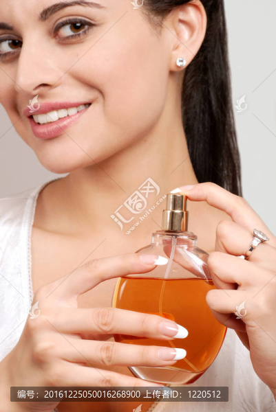 年輕女子手持香水瓶