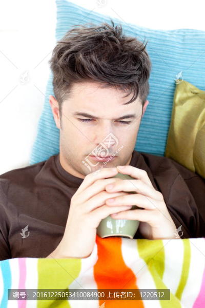 沮喪的男人拿著一杯咖啡躺在沙發(fā)上