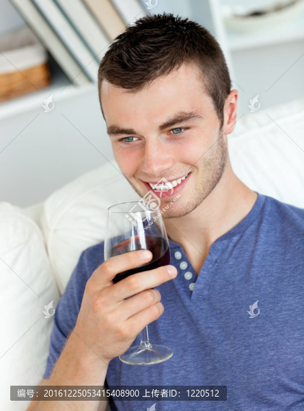 年輕人喝著酒坐在沙發(fā)上