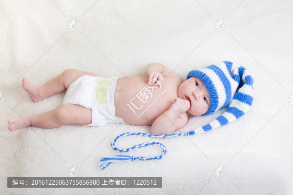 嬰兒穿著滑稽的帽子躺在毯子上