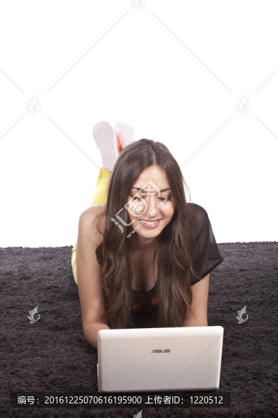 美麗的年輕女孩持有筆記本電腦全長