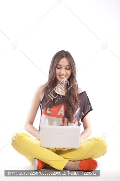 美麗的年輕女孩持有筆記本電腦全長
