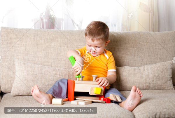 可愛的男孩在家玩木制建筑玩具