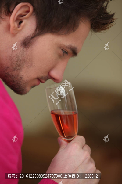 年輕人聞著一杯酒