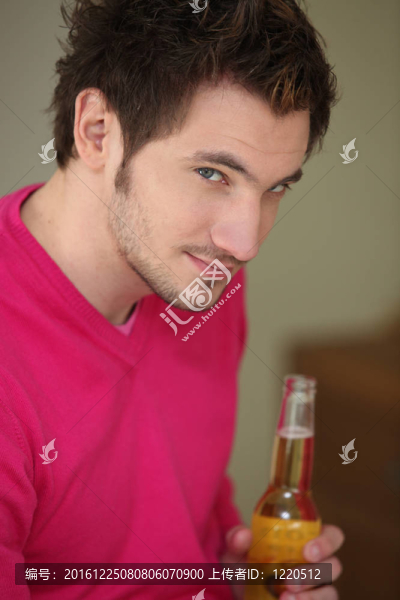 黑發(fā)男子拿著一瓶啤酒