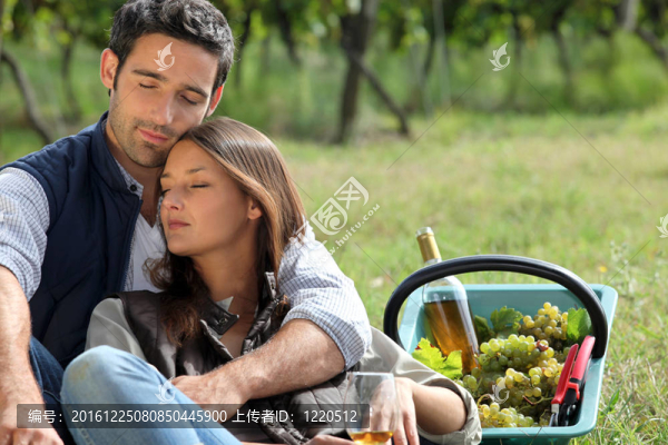 夫婦坐在裝滿葡萄的籃子旁邊