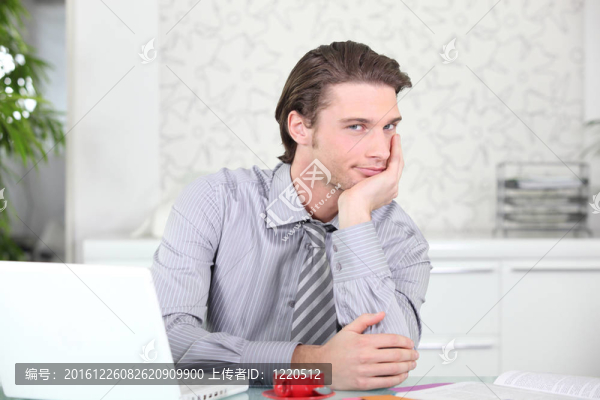 年輕英俊的男子與一個咖啡旁邊，他的筆記本電腦