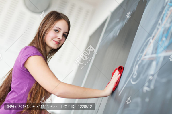 年輕漂亮的大學(xué)生寫在黑板上/黑板上數(shù)學(xué)課期間（顏色色調(diào)的圖像；淺景深）