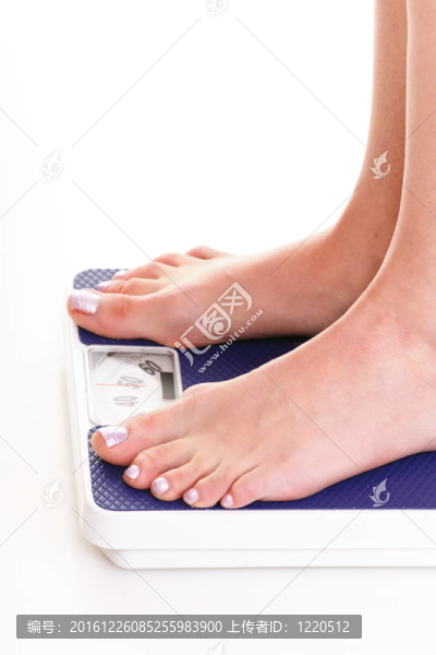 白色背景上的女人腳和體重秤
