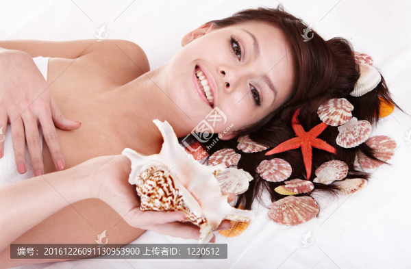 美女抱海星的年輕女子。