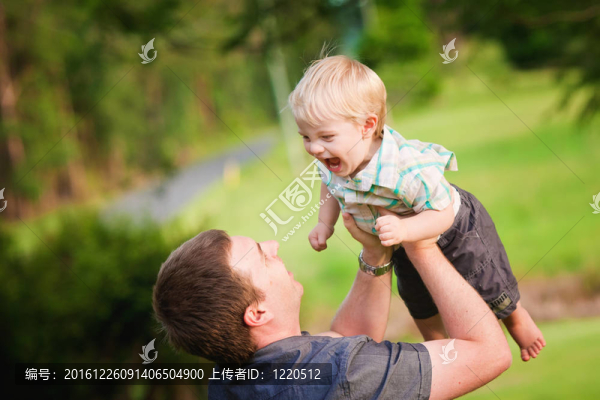 一個可愛的金發(fā)碧眼的小男孩和他的爸爸在戶外玩耍