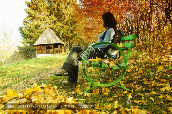 秋天公園長椅上的女人