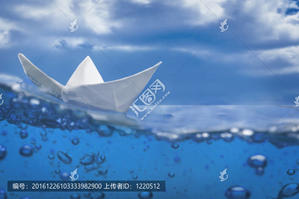 紙船飛濺與氣泡航行在藍(lán)色的水和天空