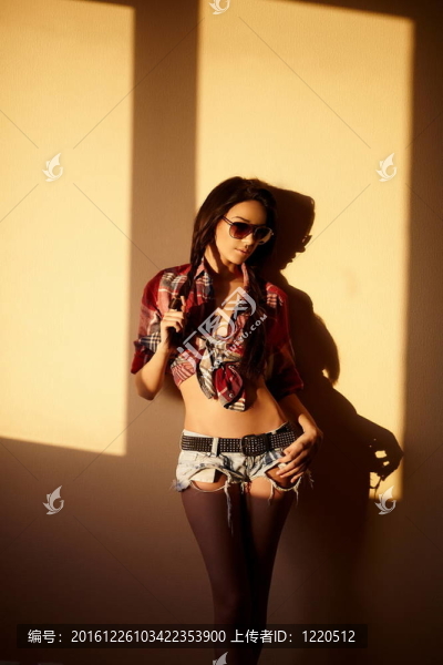 美麗時(shí)尚性感的黑人女孩穿著牛仔褲和五顏六色的襯衫在眼鏡后面的日落室內(nèi)肖像