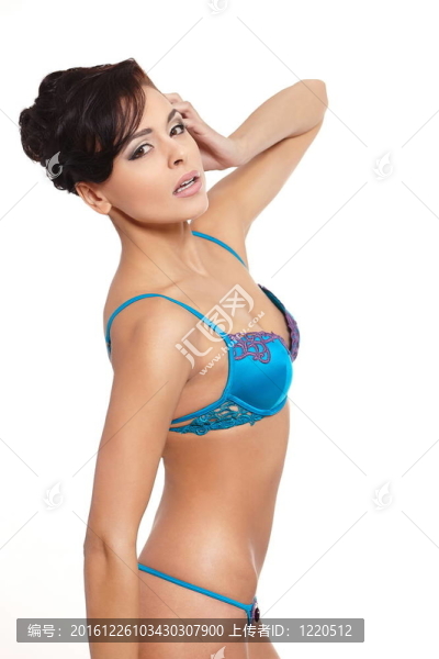 一個年輕的微笑女性時裝模特在藍色內衣背景白色背景肖像