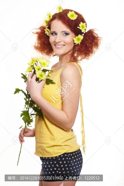 美麗的微笑的紅發(fā)女人在姜黃布抱著黃色的花，花的頭發(fā)白色隔離的肖像