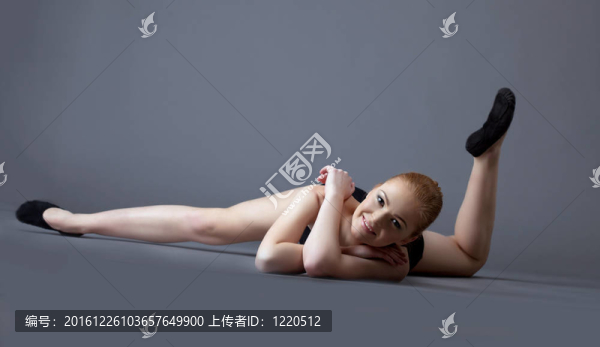 黑頂滑稽的體操女孩躺在地面
