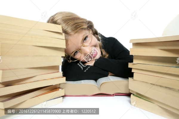 小學生金發(fā)編織女孩微笑與堆疊書籍