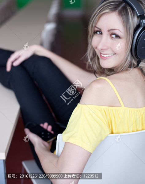 美麗的年輕女人在聽音樂