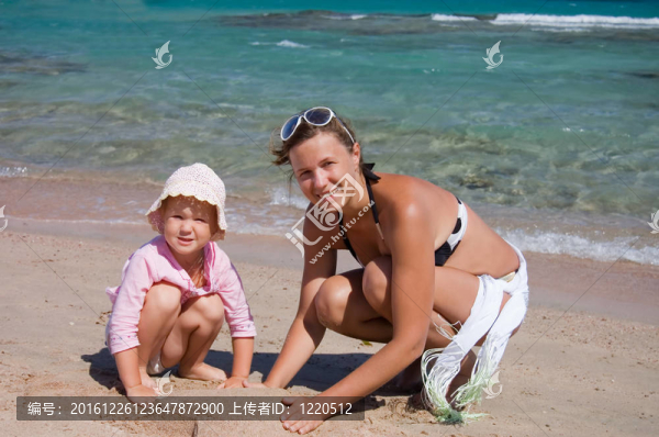 母親帶著孩子在沙灘上玩沙