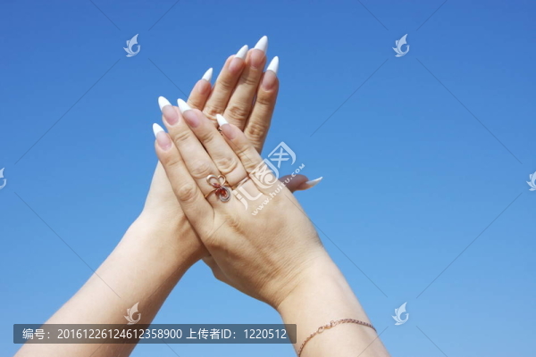 女人的手放在一個(gè)背景蔚藍(lán)的天空